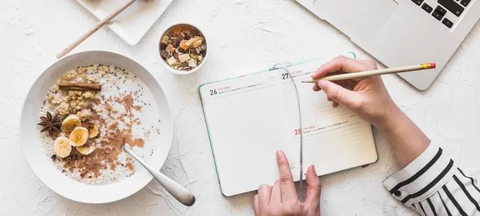 businesswoman-writing-diary-with-pencil-workplace-with-laptop-healthy-breakfast-1-1-e1706798523555